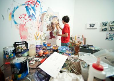 Graduate art student Eddie Villanueva works on a painting in his studio space in the Art Lofts building at the University of Wisconsin-Madison.