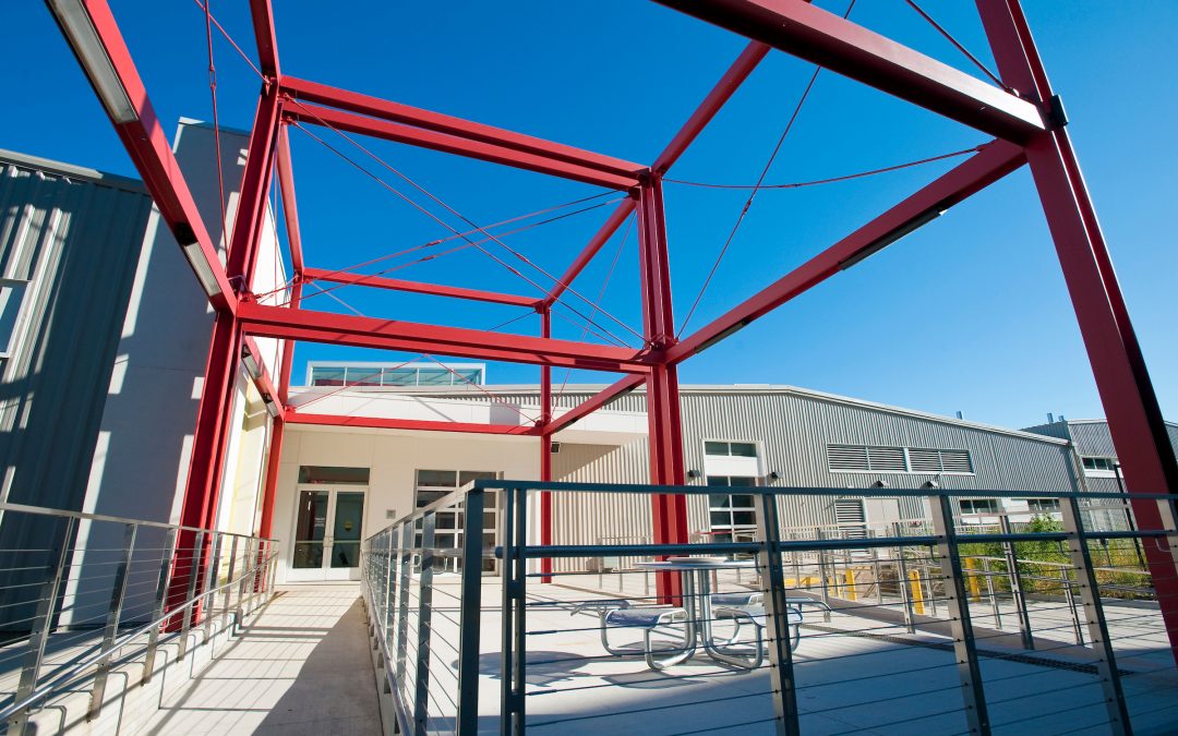 A structure of red steel beams and cables form a decorative entry to the exterior of the Art Lofts building at the University of Wisconsin-Madison. The state-of-the-art facility houses teaching spaces for several fine art disciplines as well as private studio spaces for faculty and graduate students.