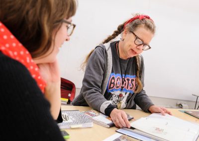 Lynda Barry reviews the work of one of her students, lecturer Allison Welch, at left, in the Making Comics class at the Mosse Humanities Building at the University of Wisconsin-Madison.