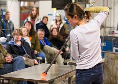 Glass artist Yuki Wakamiya works with an assortment of tools and blown air to shape a piece of molten glass during a demonstration at the Glass Lab open house at University of Wisconsin-Madison.