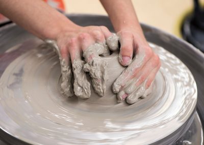 A student shapes a clay bowl on a pottery wheel at the University of Wisconsin-Madison.