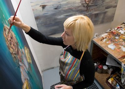 Katelyn Alain, a graduate student pursuing a master of fine arts degree in painting, works on a self portrait in her studio space in the Mosse Humanities Building at the University of Wisconsin-Madison.