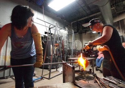 Students use a torch to heat a glass piece at the UW Glass Lab in the Art Lofts Building at the University of Wisconsin-Madison.