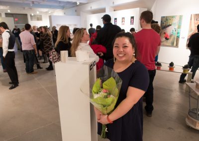 Maixia Xiong poses with her artwork at the BFA Show Reception, Gallery 7 at the University of Wisconsin-Madison