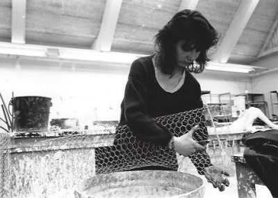 A student uses chicken wire as the base for a sculpture.