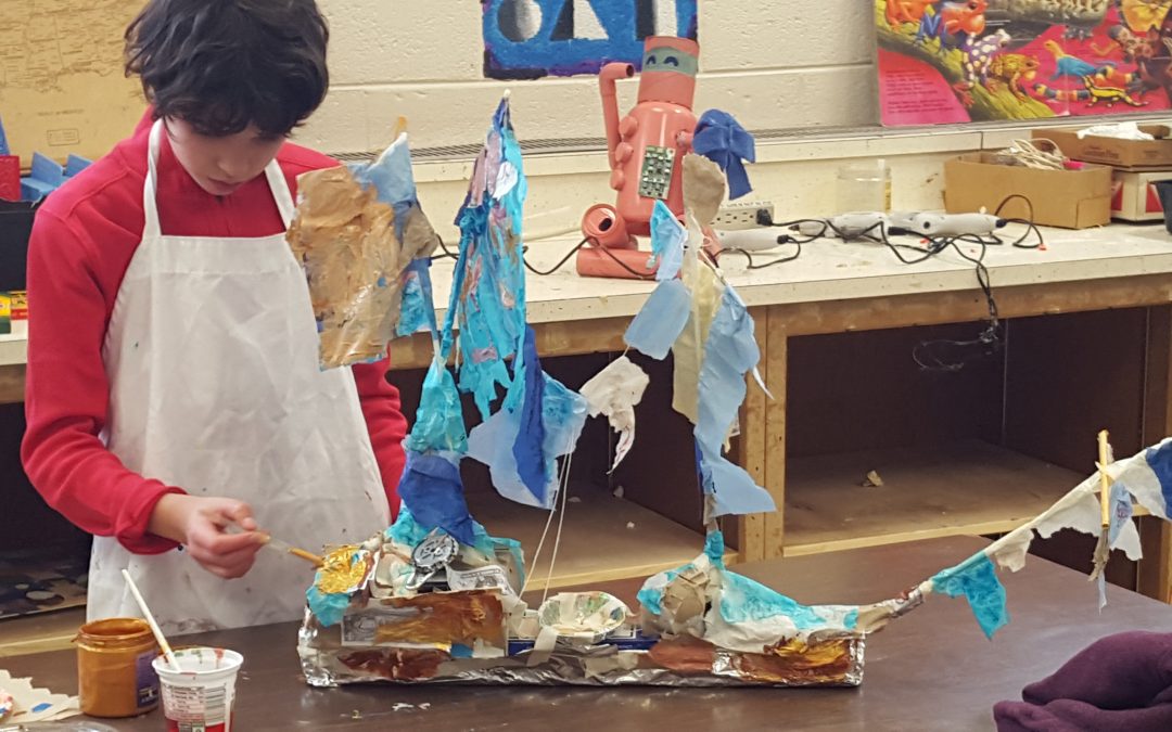 A child works on a mixed media project produced in a class taught by an Art Education major.