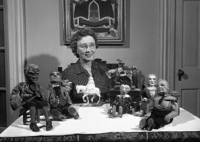 Della Wilson, Professor of Art from 1915 to 1953, poses with her collection of dolls.