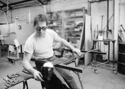 In the hot glass lab, art student Rick Findora uses a block to shape and cool molten glass on the end of a blowpipe in the November of 1985. Findora graduated with a BFA in 1986.