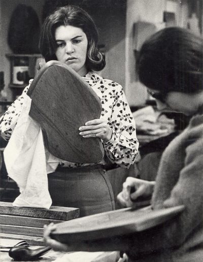 An art student works to finish a piece of carved wood in the 1960s.