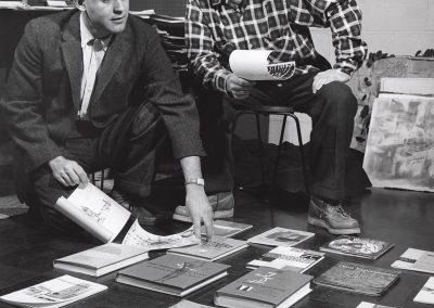 Professor of art from 1947 to 1982 Donald M. Anderson (right) and Bill H. Armstrong, an assistant professor in the department of art education from 1955 to 1963, look over books spread out on the floor.