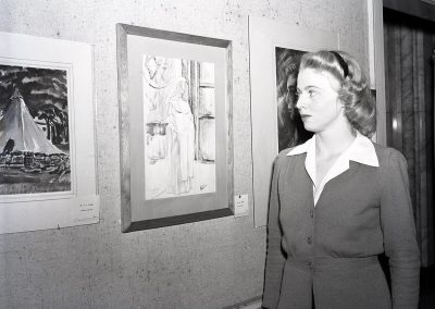 An art student poses in front of their work on display at the Memorial Union Art Salon in 1944.