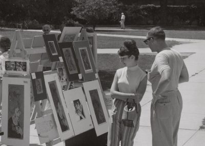 Pedestrians browse art for sale at the 1964 Union Sidewalk Art Show at the Library Mall.
