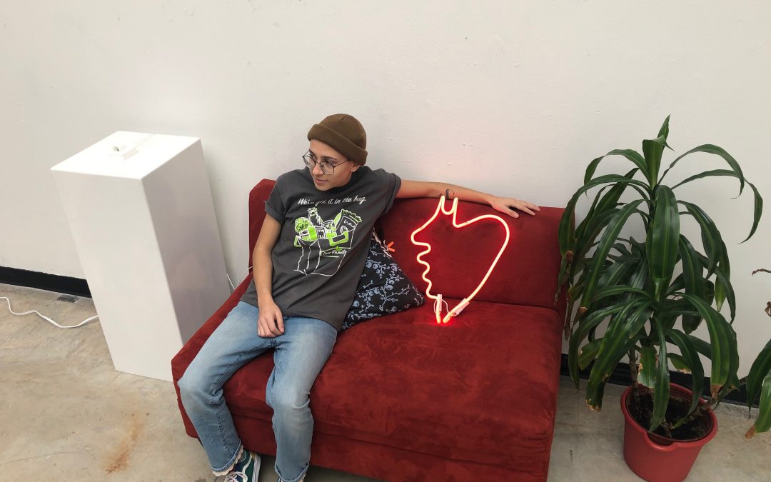 Photo of undergraduate neon student Paulina Eguino posing with her neon art.