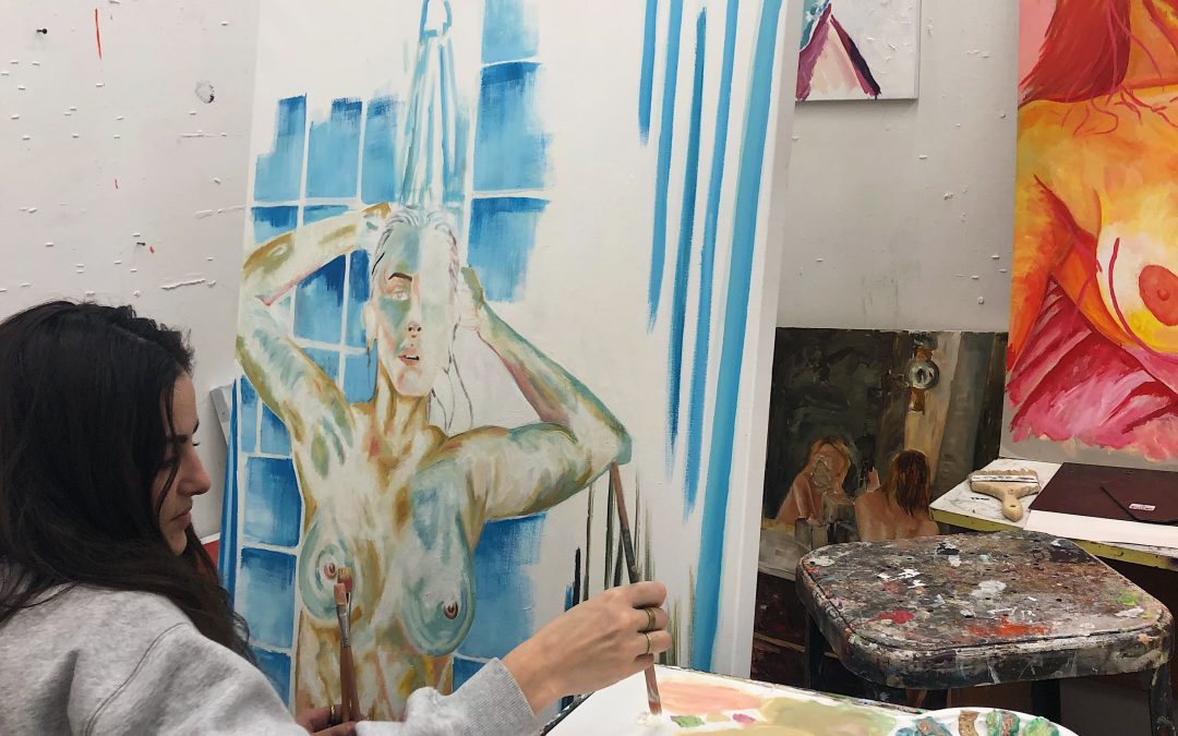 Portrait of Mia Boulukos painting in her studio.