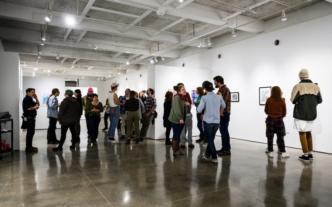 Visitors mingle and look at artwork by UW graduate art students during the closing reception for the Printmageddon Annual Grad Print Show at Gallery Seven in the Mosse Humanities Building at the University of Wisconsin-Madison. (Photo by Brian Huynh /UW-Madison)