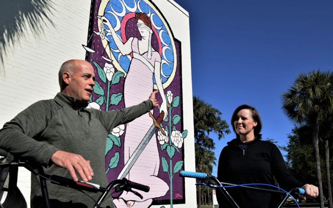 Rod and Meghan McDonald with the Blind Justice mural in downtown Brunswick, one of the points on a bike trail past murals they have laid out.