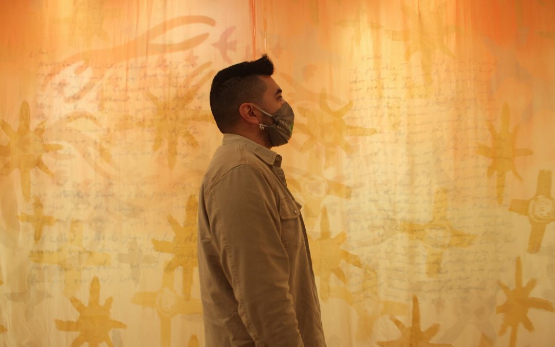 Roberto Torres Mata standing in front of his installation art at his exhibition Untethered at the Chazen Museum of Art. Photo by Elizabeth Lang.