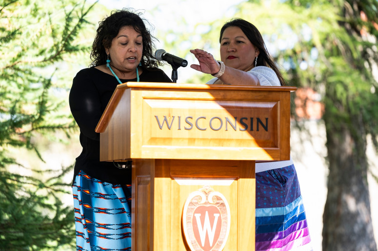 At right, Carla Vigue, UW–Madison director of tribal relations, adjusts the podium microphone for Sarah Lemieux, area representative of the Ho-Chunk Nation. PHOTO BY: JEFF MILLER