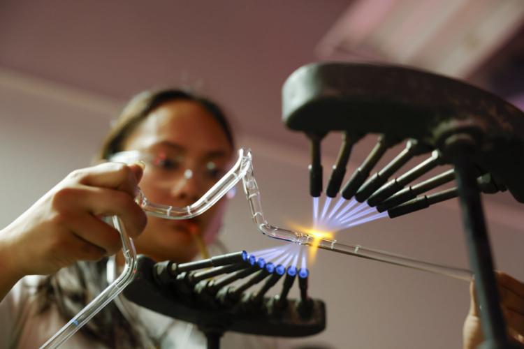 Mikee Panganiban heats a glass tube over a torch to shape it into a star June 9 in the Art Lofts building at the University of Wisconsin-Madison. Panganiban was among nine students who took a summer course called “Neon: Light as Sculpture.” Photo by Ruthie Hauge.