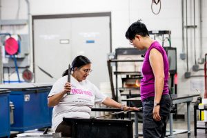 Helen Lee assisting a student in the hot shop