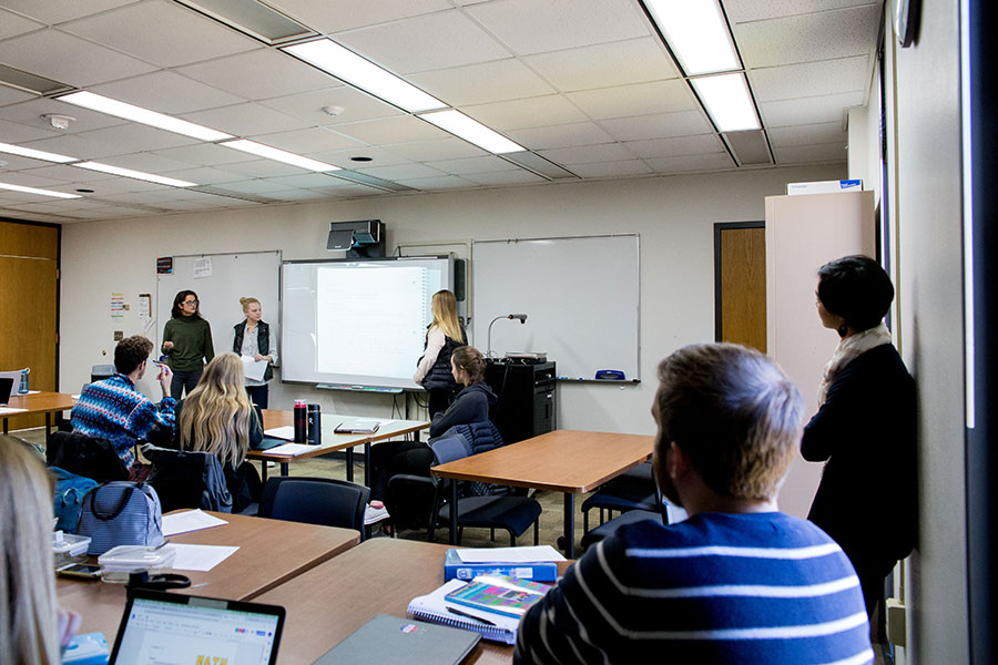 Students and teachers in a classroom giving a presentation