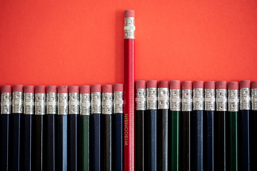 A row of black pencils with a red UW-Madison pencil