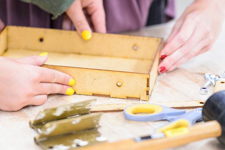 The hands of undergraduate students Montana Hodur, left, and Rachel Johnson dry-fit fabricated parts for a portable garden prototype they are creating during Design Studies 341: Design Studies for Transformation, a class held in the UW Makerspace at the University of Wisconsin-Madison on July, 11, 2018. The course projects were researched as part of an outreach effort to meet local farms and farmers' market needs. The interdisciplinary, summer-session class is a joint venture between the College of Engineering and the School of Human Ecology