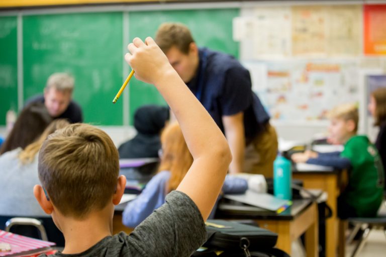 Child raising hand in classroom